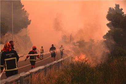 Ein heftiger Vegetationsbrand wütet an der kroatischen Adria-Küste: Feuerwehrleute löschen Brände neben einer Straße
