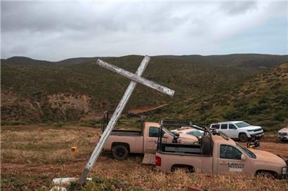 Ein hölzernes Kreuz ist neben Armeefahrzeugen in der Nähe des Fundortes menschlicher Überreste am Strand La Bocana in Santo Tomas in Baja California zu sehen
