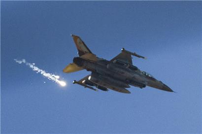 Ein israelisches Kampfflugzeug feuert Leuchtraketen ab, während es den Gazastreifen überfliegt
