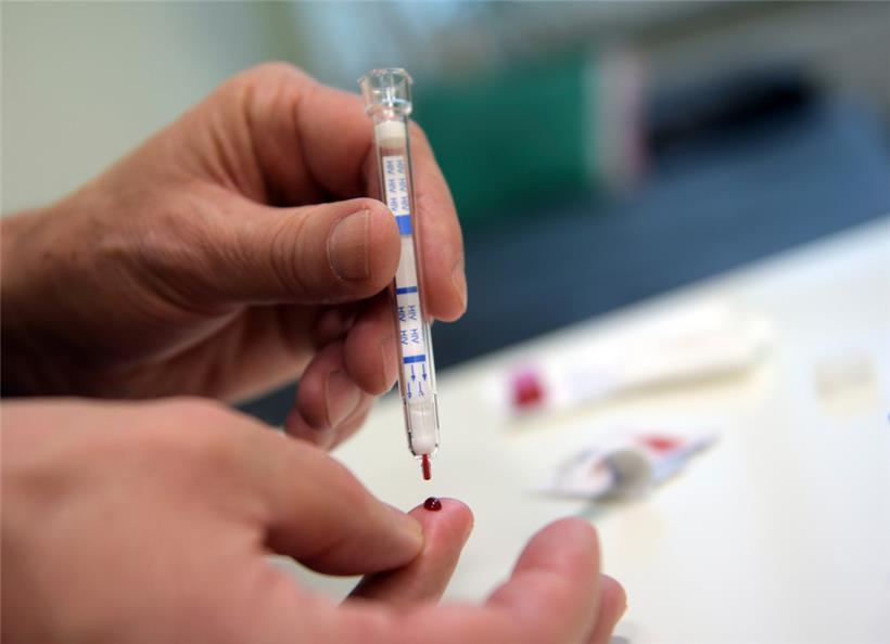 Ein junger Mann führt einen HIV-Heimtest durch
