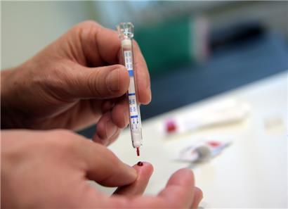 Ein junger Mann führt einen HIV-Heimtest durch
