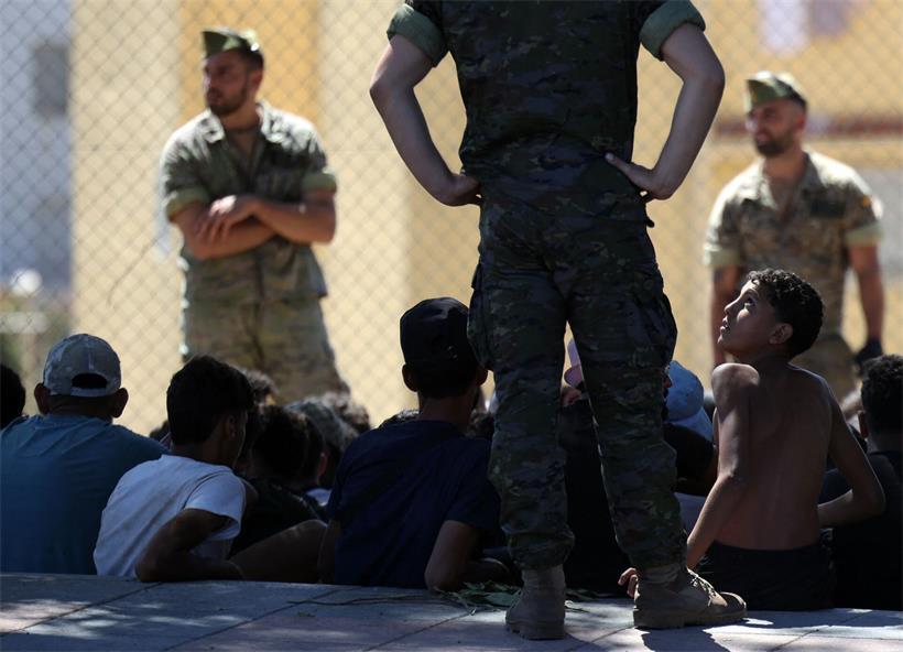 Ein junger Migrant blickt auf einen Angehörigen der spanischen Armee, kurz bevor die Gruppe nach Marokko zurückgebracht wird