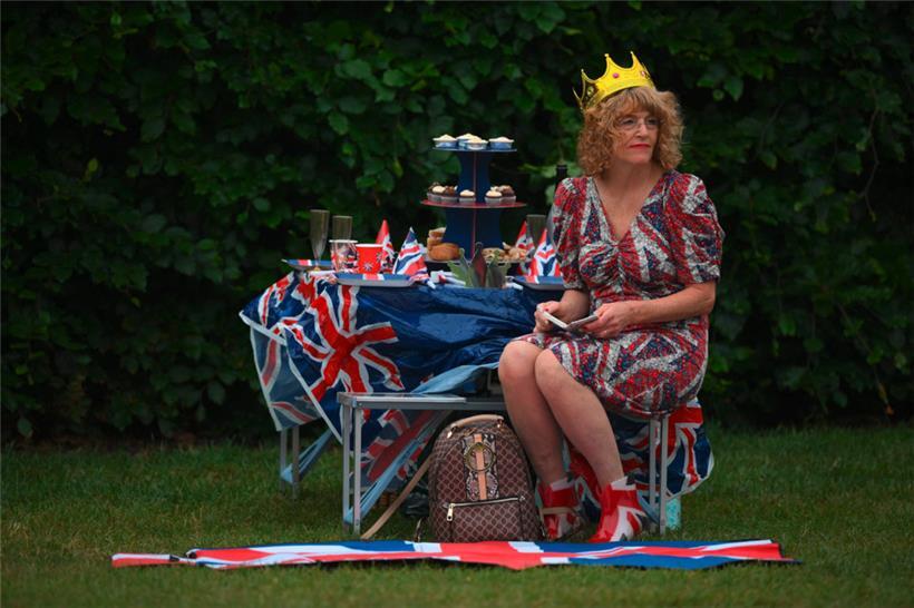 Ein königlicher Fan in einem Kleid mit Union-Flagge und Stiefeln nimmt am 5. Juni 2022 am „Big Jubilee Lunch“ auf dem „Long Walk“ in Windsor, westlich von London, im Rahmen der Feierlichkeiten zum Platinjubiläum von Königin Elisabeth II. teil
