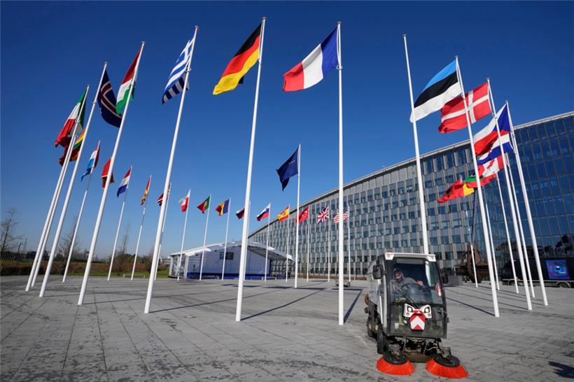 Ein leerer Fahnenmast steht zwischen den Nationalflaggen von Frankreich und Estland vor dem NATO-Hauptquartier
