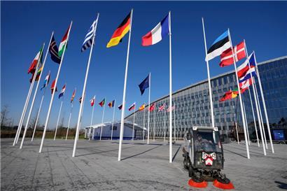 Ein leerer Fahnenmast steht zwischen den Nationalflaggen von Frankreich und Estland vor dem NATO-Hauptquartier

