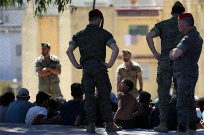 Ein marokkanischer Junge sieht zu einem spanischen Soldaten hoch: Vor einer Woche waren ebenfalls tausende unbegleitete Kinder und Jugendliche von Marokko nach Ceuta gekommen. Viele von ihnen halten sich weiterhin in der spanischen Exklave auf.
