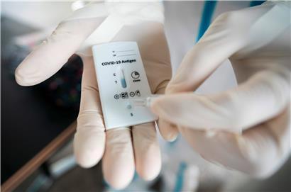 Ein medizinischer Angestellter in Wien wertet einen Covid-19-Antigentest aus
