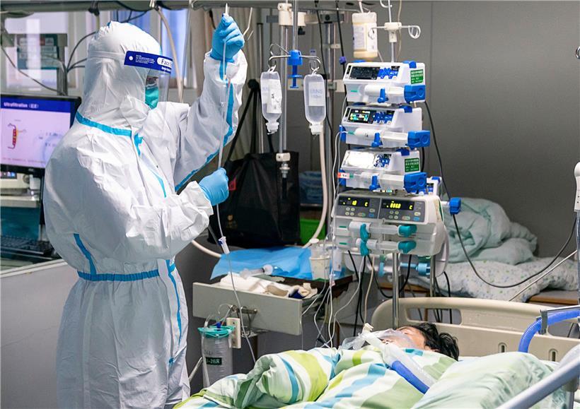 Ein medizinischer Mitarbeiter überprüft den Tropf eines Patienten auf der Intensivstation des Krankenhauses „Zhongnan“ der Universität Wuhan. China baut in aller Schnelle ein Krankenhaus zur Behandlung von Patienten, die mit dem neuen Virus infiziert sind. 
