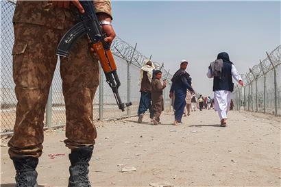 Ein pakistanischer Soldat an der gemeinsamen Grenze, im Hintergrund afghanische Flüchtlinge: Dass die Taliban immer noch als Oppositionskraft existieren, verdanken sie vor allem der Unterstützung aus Pakistan
