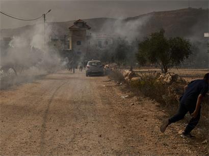 Ein palästinensischer Jugendlicher flieht vor Tränengas, das von Angehörigen der israelischen Streitkräfte nach einem Angriff von Siedlern während der Olivenernte im Dorf Abu Falah im Westjordanland abgefeuert wurde