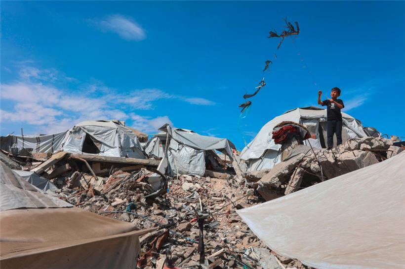 Ein palästinensischer Junge lässt am 4. Mai 2025 in Gaza-Stadt in der Nähe von Zelten, die auf Trümmern errichtet wurden, einen Drachen steigen
