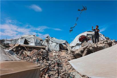 Ein palästinensischer Junge lässt am 4. Mai 2025 in Gaza-Stadt in der Nähe von Zelten, die auf Trümmern errichtet wurden, einen Drachen steigen
