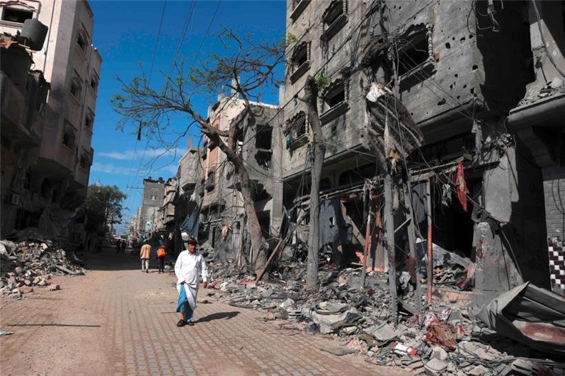 Ein palästinensischer Mann geht am 14. November 2023 in Bureij im Zentrum des Gazastreifens an Gebäuden vorbei, die während der israelischen Bombardierung des Gazastreifens zerstört wurden
