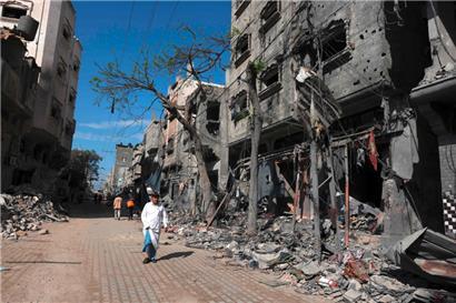 Ein palästinensischer Mann geht am 14. November 2023 in Bureij im Zentrum des Gazastreifens an Gebäuden vorbei, die während der israelischen Bombardierung des Gazastreifens zerstört wurden

