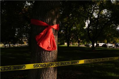 Ein rotes Band hängt an einem Baum hinter dem Absperrband der Polizei an der Utah Valley University. Nach dem tödlichen Angriff auf den rechten US-Aktivisten Kirk ist US-Präsident Trump zufolge „mit hoher Wahrscheinlichkeit“ der Tatverdächtige gefasst worden. Er sei in Gewahrsam, sagte der Republikaner im Sender Fox News.
