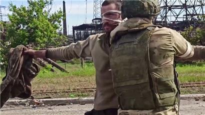 Ein russischer Soldat durchsucht einen ukrainischen Infanteristen nach der Evakuierung

