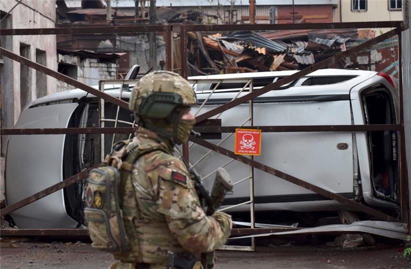 Ein russischer Soldat steht in der ukrainischen Hafenstadt Mariupol vor dem zerstörten Teil des Iljitsch-Eisen- und Stahlwerks Wache
