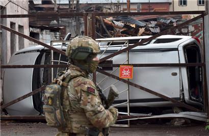 Ein russischer Soldat steht in der ukrainischen Hafenstadt Mariupol vor dem zerstörten Teil des Iljitsch-Eisen- und Stahlwerks Wache
