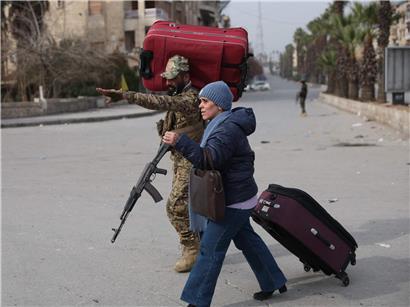 Ein syrischer Soldat hilft einem Bewohner, der am 8. Januar 2026 aus den überwiegend kurdischen Vierteln Sheikh Maqsud und Ashrafiyeh in der Stadt Aleppo im Norden Syriens flieht – während es zu heftigen Kämpfen zwischen Regierungstruppen und den kurdischen Syrischen Demokratischen Kräften (SDF) kommt