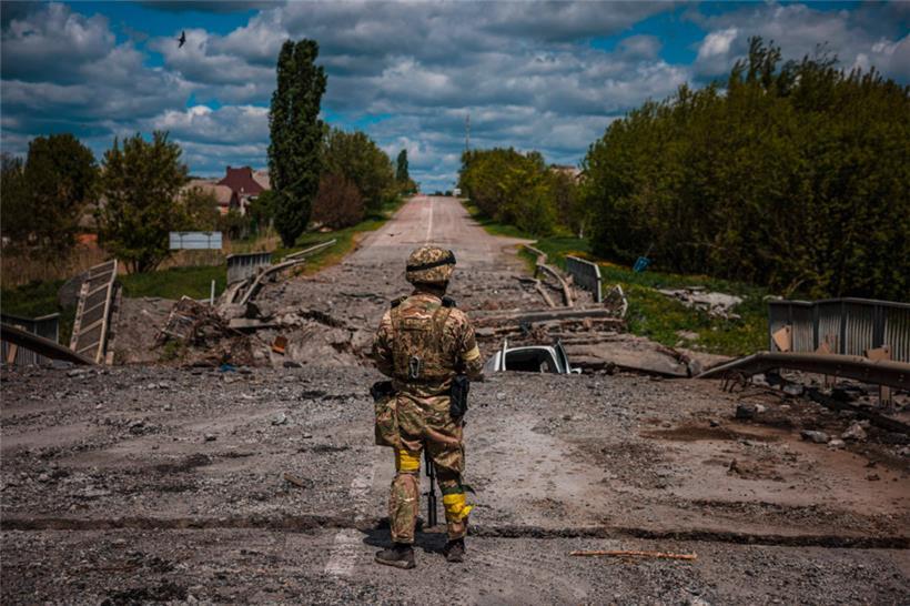 Ein ukrainischer Soldat in der Nähe von Charkiw: In der Ukraine liegen auch zahllose Straßen, Brücken und Industrieanlagen in Schutt und Asche
