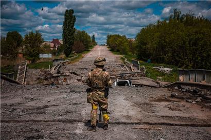 Ein ukrainischer Soldat in der Nähe von Charkiw: In der Ukraine liegen auch zahllose Straßen, Brücken und Industrieanlagen in Schutt und Asche
