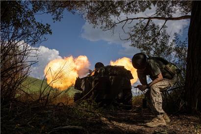 Ein ukrainischer Soldat steht hinter einer Panzerartillerie, die an einer Frontlinie in der Region Charkiw auf russische Truppen schießt
