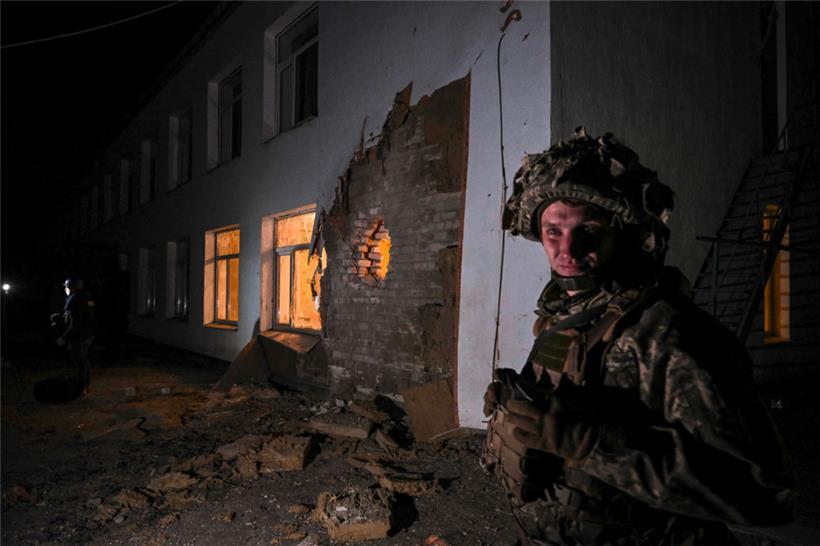Ein ukrainischer Soldat steht in der ostukrainischen Ortschaft Stanyzia-Luhanska neben einem Gebäude, das offenbar einen Kindergarten beherbergt und vermutlich von Separatisten beschossen wurde
