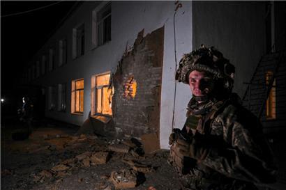 Ein ukrainischer Soldat steht in der ostukrainischen Ortschaft Stanyzia-Luhanska neben einem Gebäude, das offenbar einen Kindergarten beherbergt und vermutlich von Separatisten beschossen wurde
