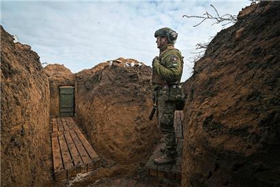 Ein ukrainischer Soldat steht in einem Schützengraben außerhalb der befreiten ukrainischen Stadt Cherson
