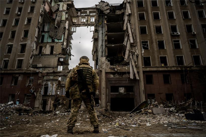 Ein ukrainischer Soldat steht vor dem zerstörten Gebäude der Regierungsverwaltung in Mykolajiw
