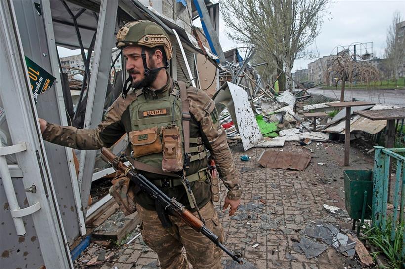 Ein ukrainischer Soldat steht vor einem Haus in Trümmern im Westen der zerstörten Stadt Bachmut
