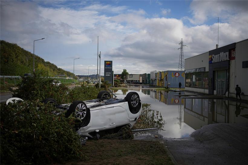 Ein umgestürztes Auto ist auf dem Parkplatz eines Einkaufszentrums in Givors, Zentralfrankreich, zu sehen, nachdem starke Regenfälle und Überschwemmungen Straßen und Bahngleise überflutet hatten
