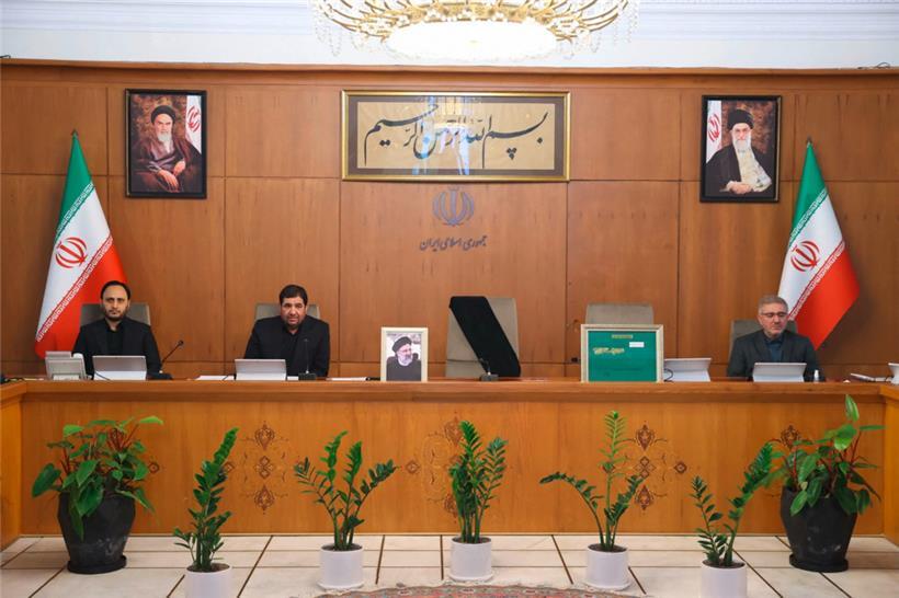Ein von der iranischen Regierung veröffentlichtes Bild zeigt Irans Vizepräsidenten Mohammad Mokhber (2. v. l.) während einer Kabinettssitzung in Teheran am 20. Mai 2024. Der Sitz des verstorbenen Präsidenten Ebrahim Raisi (Porträt) neben ihm ist leer.
