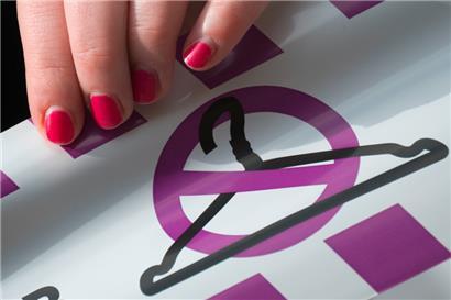 Eine Aktivistin hält ein Band mit einem durchgestrichenen Kleiderbügel. Früher haben manche Frauen mit dem Kleiderbügel eine ungewollte Schwangerschaft abgebrochen.
