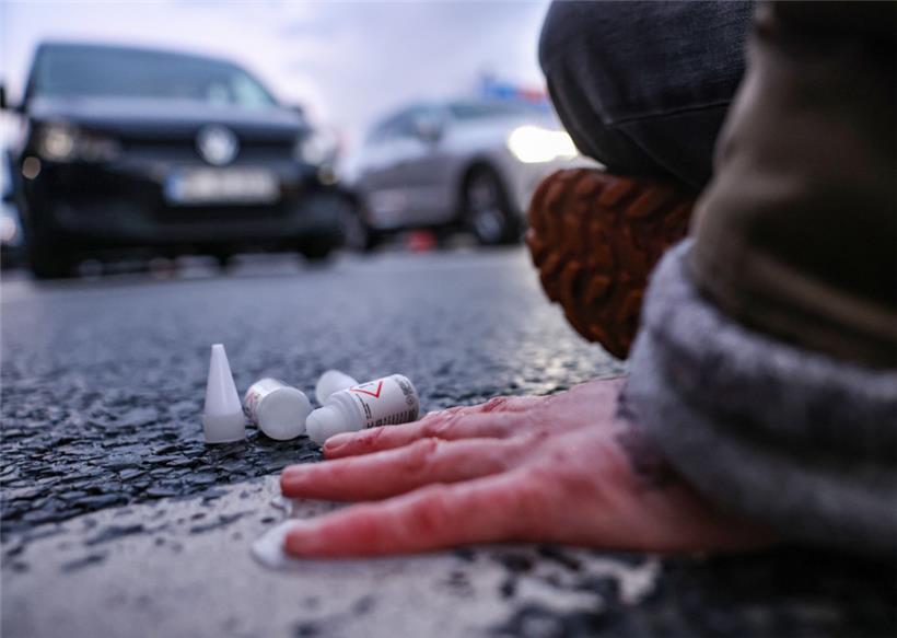 Eine Aktivistin hat sich auf einer Straßenkreuzung an die Fahrbahn geklebt