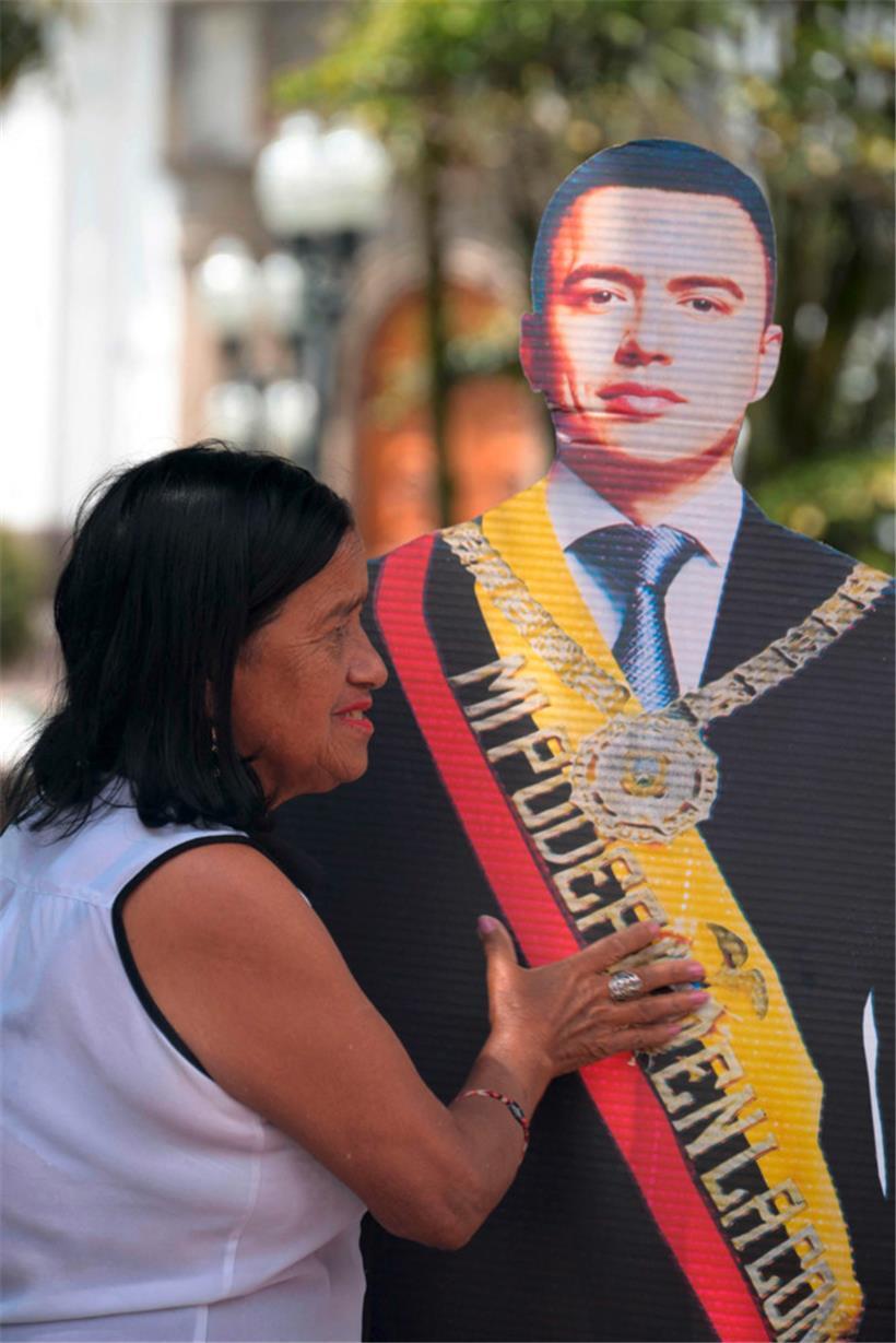 Eine Anhängerin trägt Amtsinhaber Daniel Noboa als Pappfigur über die Plaza Grande in Quito.
