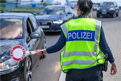 Eine Beamtin der Bundespolizei stoppt ein Fahrzeug bei der Einreisekontrolle
