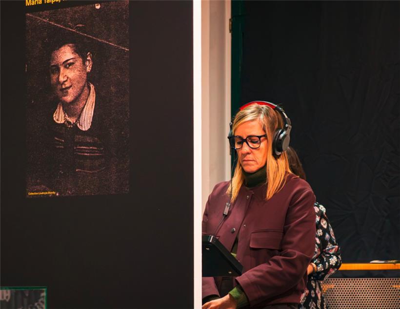 Eine Besucherin hört dem Interview einer ehemaligen Ostarbeiterin in der Ausstellung zu
