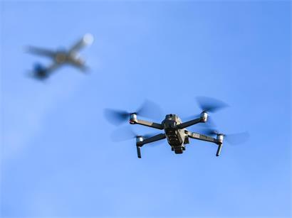 Eine Drohne fliegt vor einem startenden Flugzeug in der Nähe des Flughafens Leipzig/Halle im Dezember 2025