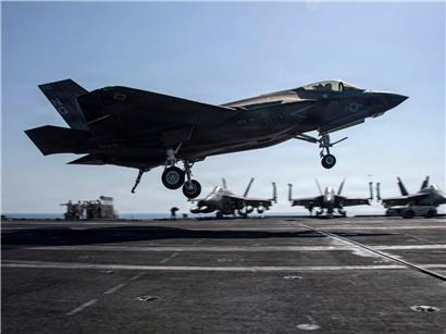 F-35C Lightning II Kampfjet bei der Landung auf Flugdeck eines Flugzeugträgers unter klarem Himmel