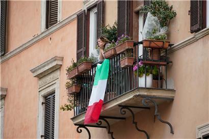 Eine Frau beobachtet die Straße von einem Balkon aus, an dem die italienische Flagge befestigt ist. Der Präsident des nationalen Gesundheitsinstitutes (ISS), Brusaferro, warnte trotz der leichten Abflachung der Infektionskurve vor einer Lockerung der Ausgangssperren.
