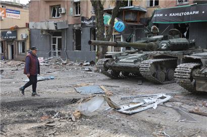 Eine Frau geht am 4. Mai in Mariupol an Panzern der Miliz der Donezker Volksrepublik in Mariupol vorbei

