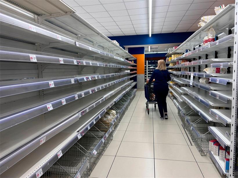Eine Frau geht in einem Supermarkt in Neapel an leeren Regalen vorbei
