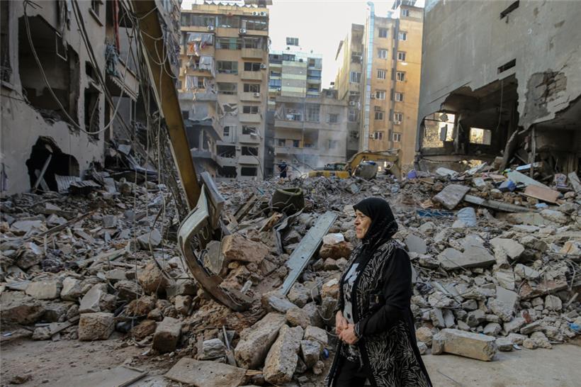 Eine Frau reagiert, als sie vor den von israelischen Luftangriffen zerstörten Gebäuden im Zentrum von Beirut läuft
