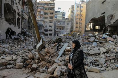 Eine Frau reagiert, als sie vor den von israelischen Luftangriffen zerstörten Gebäuden im Zentrum von Beirut läuft
