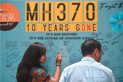 Eine Frau schreibt eine Nachricht während einer Veranstaltung, die anlässlich des 10. Jahres seit dem Verschwinden des Malaysia-Airlines-Fluges MH370 mit 239 Menschen an Bord von den Radarschirmen am 8. März 2014 auf dem Weg von Kuala Lumpur nach Peking in Subang Jaya abgehalten wurde
