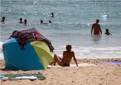 Eine Frau sonnt sich am Strand von Cala Major. Angesichts steigender Corona-Zahlen wurde nun ganz Spanien zum einem Corona-Risikogebiet erklärt.
