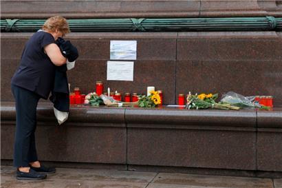Eine Frau steht vor dem Gesundheitsministerium in Wien vor Blumen und Kerzen, die für die verstorbene Ärztin niedergelegt wurden
