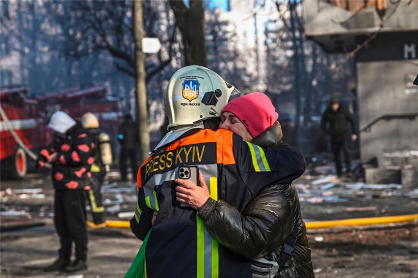 Eine Frau sucht nach einem Bombeneinschlag in Kiew Trost 
