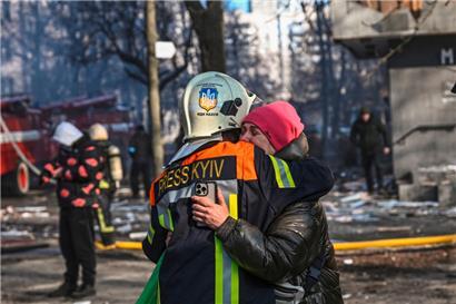 Eine Frau sucht nach einem Bombeneinschlag in Kiew Trost 
